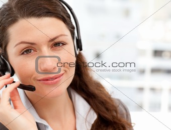 Pretty businesswoman with earpiece smiling at the camera