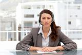 Attractive businesswoman speaking using headset sitting at a tab