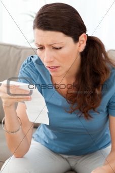 Nervous woman looking at a bill while doing her accounts