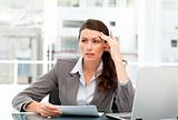Serious female executive finding ideas while working at her desk