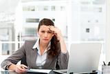 Worried businesswoman working at her desk with laptop and folder