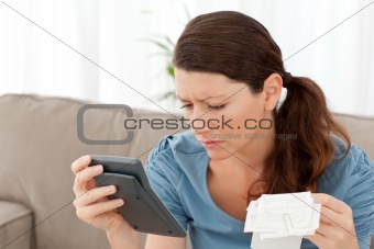 Attractive woman holding a calculator and bills  