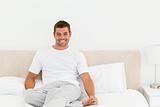 Happy man relaxing on his bed at home