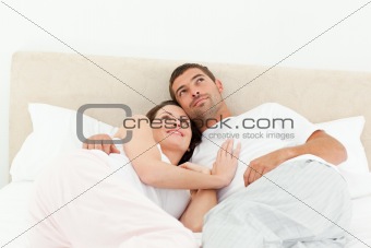 Relaxed couple lying together on their bed in the morning