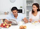Businessman reading the newspaper with his girlfriend during breakfast