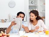 Happy couple reading the newspaper together during breakfast