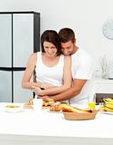 Happy couple hugging while preparing their breakfast together 
