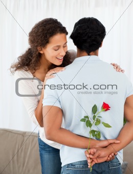 Beautiful woman finding a rose hidden by her boyfriend