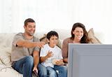 Family laughing while watching television together