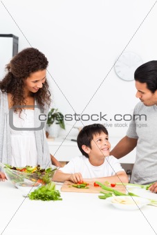 Happy family cutting vegetables together in the kitchen