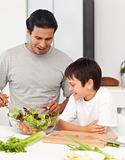 Handsome man preparing a salad with his son