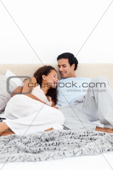 Passionate couple lying together on their bed 