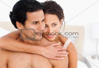 Lovely couple hugging sitting together on their bed 