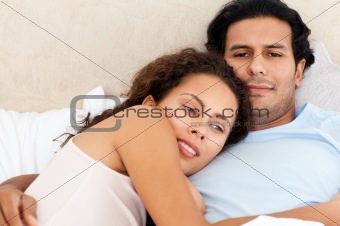 Portrait of a passionate couple lying together on their bed