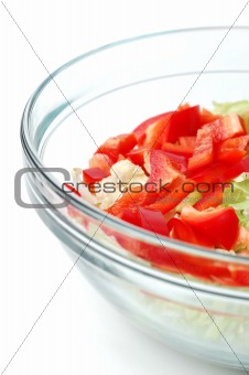 Healthy salad with vegetables in a stylish glass bowl isolated on white background
