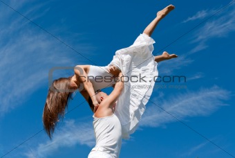 young couple dancing on sky background, freedom and relax symbol 