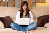 Young woman with laptop portable computer sitting on sofa