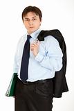 Thoughtful young businessman with jacket on his shoulder holding folder in  hand
