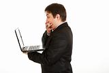 Shocked modern businessman  looking in laptops screen
