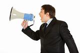 Frustrated young businessman yelling through megaphone
