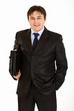 Smiling young businessman with  briefcase in hand
