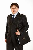 Smiling young businessman holding briefcase on shoulder
