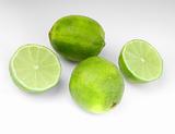 four lime fruit on gray background