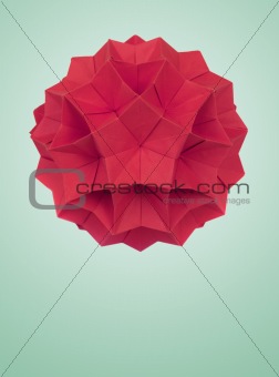 Origami ball on gray background