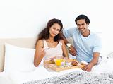 Pretty woman having breakfast on the bed with her boyfriend