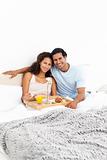 Portrait of a cute couple having breakfast in their bed