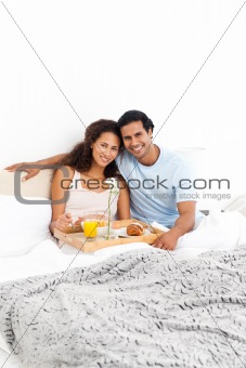 Portrait of a cute couple having breakfast in their bed