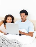 Passionate woman looking her husband working on his laptop