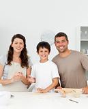 Cute boy with his parents in his kitchen