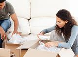 Happy woman packing glasses with her husband in the living-room