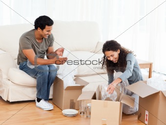 Happy couple packing glasses together in the living-room 