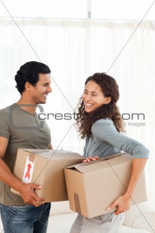 Lovely couple holding cardboards in their living-room