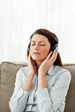 Concentrated woman listening music on the sofa