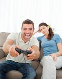 Bored woman waiting for her boyfriend playing video games