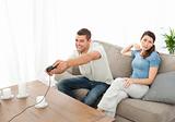 Desperate woman being bored while her boyfriend playing video game
