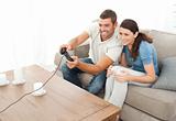 Attentive couple playing video game together in the living room 
