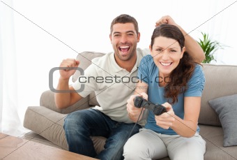 Cheerful man encouraging his girlfriend playing video game