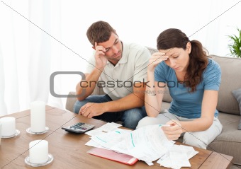 Worried couple doing their accounts in the living room