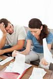 Stressed man and woman looking at their bills in the living room