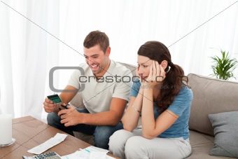 Happy man cutting his credit card with scissors with his girlfri