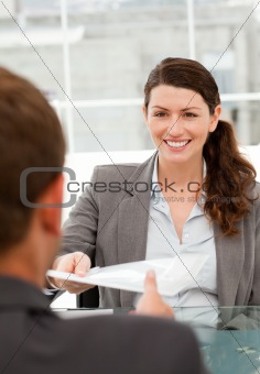 Happy businesswoman giving a paper to a male colleague