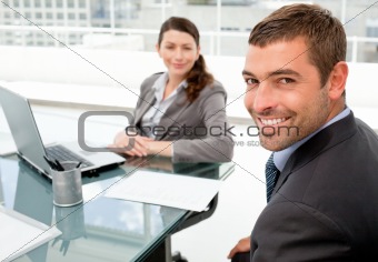 Cheerful business people working on a laptop during a meeting 