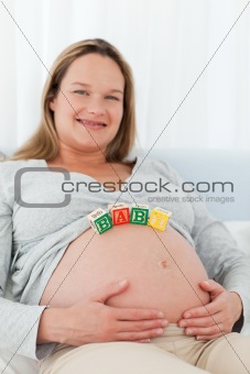 Portrait of a future mom with baby letters on her belly