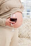 Close up of a pregnant woman with glass of red wine and cigarette