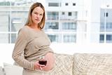 Young pregnant woman holding red wine and a cigarette