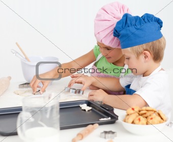 Two adorable children making biscuits together